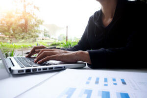 Businesswoman sitting at a desk, focused on editing website content on her laptop, illustrating the process of improving conversion copywriting.